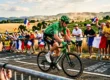Cycliste professionnel en vert pédalant devant foule française
