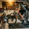 Homme à vélo sur home-trainer dans un garage bien équipé